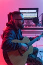 Create music and a recording studio concept - Bearded man guitarist recording electric guitar track in home studio Royalty Free Stock Photo