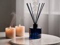 Create a serene atmosphere with navy blue reed diffuser and soft beige candles on marble. Royalty Free Stock Photo
