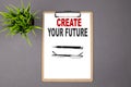 CREATE YOUR FUTURE on the brown clipboard on the grey background. Business concept