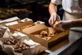 A baker packaging freshly baked goods in an artisan bakery, showcasing the final product with beautiful packaging. Generative AI