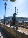 The statue of the Little Princess statue sitting on the railings of the Danube promenade in Budapest