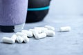 Creatine capsules. Glass of Protein Shake with milk and blueberries and black sporting kettlebell in background. Sport nutrition. Royalty Free Stock Photo