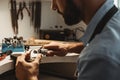 Creating a beauty. Close-up portrait of bearded male jeweler polishing a detail