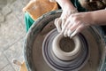 Creating a clay pot on a potter`s wheel, the potter`s hand is viewed from above Royalty Free Stock Photo