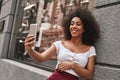 Creating happy memories. Attractive and young Afro American woman taking selfie while spending time in the city