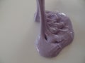 Creating patterns out of lilac coloured glossy slime