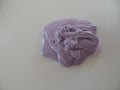 Creating patterns out of lilac coloured glossy slime