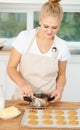 Creating pure decadence at home - Baking. Beautiful young woman baking cookies at home. Royalty Free Stock Photo