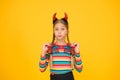 Creating spooky holiday look. Small girl wear Halloween holiday costume accessories. Little child dressed as devil for