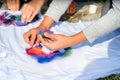 Creating your own t-shirt workshop outside. Hand applying paint