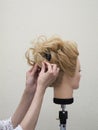 Creation of a hairstyle on a mannequin. Royalty Free Stock Photo