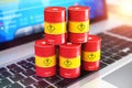 Red oil drums on laptop with stock exchange market app