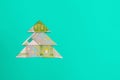 Creative alternative Christmas Tree made from one hundred euro banknotes on light green background Royalty Free Stock Photo