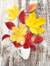 Creative arrangement autumn leaves and coffee cup on wooden background. Autumn concept Royalty Free Stock Photo