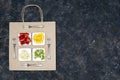 Creative arrangement of four small plates with sliced fruits and four forks on a flat paper shopping bag against grunge background Royalty Free Stock Photo