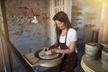 Creative artisan shaping clay on a wheel in her studio