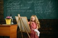 Creative artist painting on studio easel. Little artist girl creating picture in class