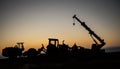 Abstract Industrial background with construction crane silhouette over amazing sunset sky. Mobile crane against the evening sky. Royalty Free Stock Photo