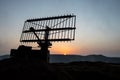 Creative artwork decoration. Silhouette of mobile air defence truck with radar antenna during sunset. Satellite dishes or radio Royalty Free Stock Photo