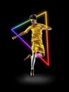 Creative artwork of prfessional male football player in motion over neon geometric element isolated over black