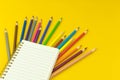 Creative back to school desktop background with blank notebook and color drawing pencils