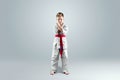 Creative background, a child in a white kimono in a fighting stance, on a light background Royalty Free Stock Photo