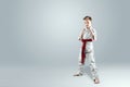 Creative background a child in a white kimono in a fighting stance, on a light background Royalty Free Stock Photo