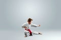 Creative background a child in a white kimono in a fighting stance, on a light background The concept of martial arts Royalty Free Stock Photo