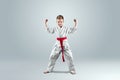 Creative background a child in a white kimono in a fighting stance, on a light background The concept of martial arts Royalty Free Stock Photo