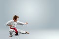 Creative background a child in a white kimono in a fighting stance, on a light background The concept of martial arts Royalty Free Stock Photo