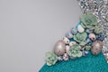 Creative background of combination of paper, glitter, succulents and eggs in blue and green tones for easter text