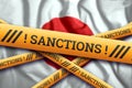 Creative background, the inscription on the flag of Japan, sanctions, yellow fencing tape. The concept of sanctions, policies,
