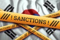 Creative background, the inscription on the flag of South Korea, sanctions, yellow fencing tape. The concept of sanctions,