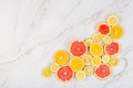 Creative background made of summer tropical fruits with grapefruit, orange, tangerine, lemon, lime on white marble background.