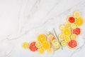 Creative background made of summer tropical fruits with grapefruit, orange, tangerine, lemon, lime on white marble background.