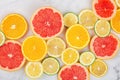 Creative background made of summer tropical fruits with grapefruit, orange, tangerine, lemon, lime on white marble background.