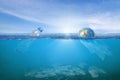 Creative background, World wrapped in plastic floating in the ocean, a bottle in the water Royalty Free Stock Photo