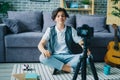 Creative boy vlogger recording video for online vlog speaking on floor at home Royalty Free Stock Photo