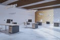Creative bright concrete and wooden coworking office interior with furniture and equipment.