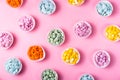 Creative bright pink background with heaps of multicolored chocolate drops