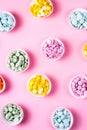 Creative bright pink background with heaps of multicolored chocolate drops