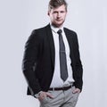 Creative business man stands with his hands in his pockets. on grey background Royalty Free Stock Photo