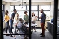 Creative business team listening to presentation at a brainstorm meeting, seen from doorway