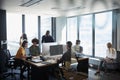 Creative business team working together in a busy casual office, seen through glass door