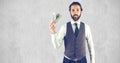 Creative businessman holding currencies while standing against wall Royalty Free Stock Photo