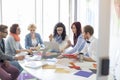 Creative businesspeople analyzing photographs at conference table in office