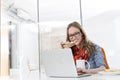 Creative businesswoman having breakfast while working on laptop in office