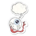 A creative cartoon injured eyeball and thought bubble as a distressed worn sticker