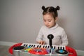 Creative child plays the synthesizer. Little girl learning to play the piano Royalty Free Stock Photo