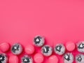 Creative Christmas composition with pink tennis balls and shiny disco balls on vivid pink background. Minimal Xmas or New Year cel